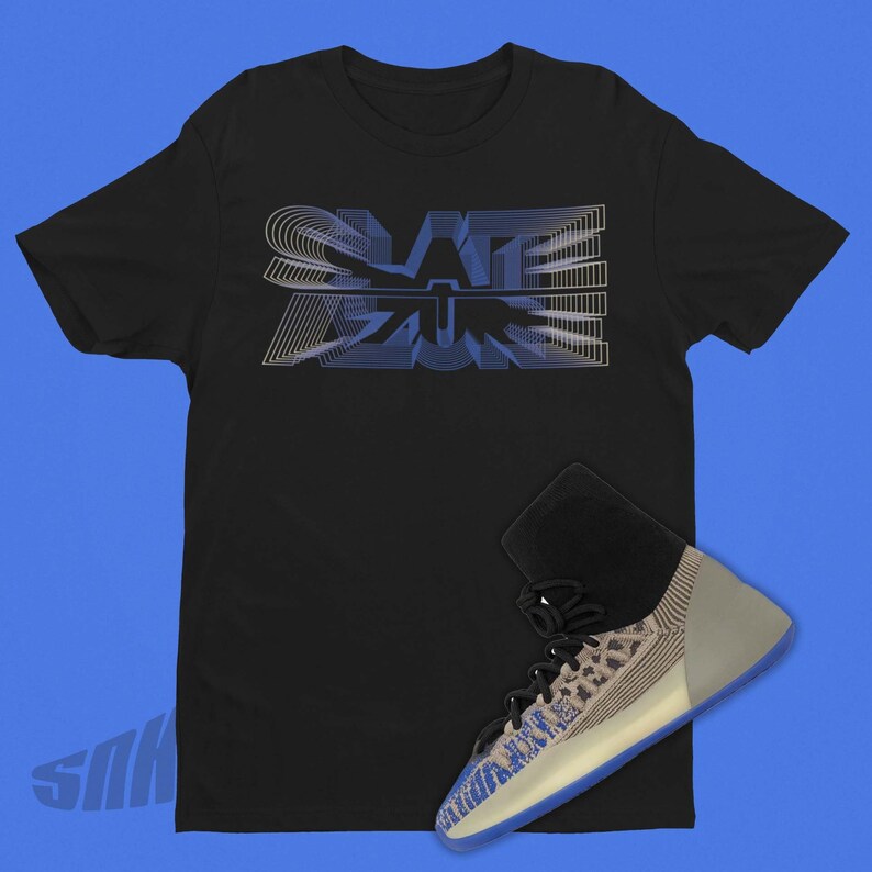 May include: A black t-shirt with a blue and white graphic that says "SLATE" on it. A pair of blue and white sneakers are placed on the t-shirt.