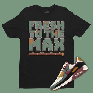 May include: Black t-shirt with the text "Fresh to the Max" in green and orange. A pair of white, black, green, and brown sneakers with a red swoosh.