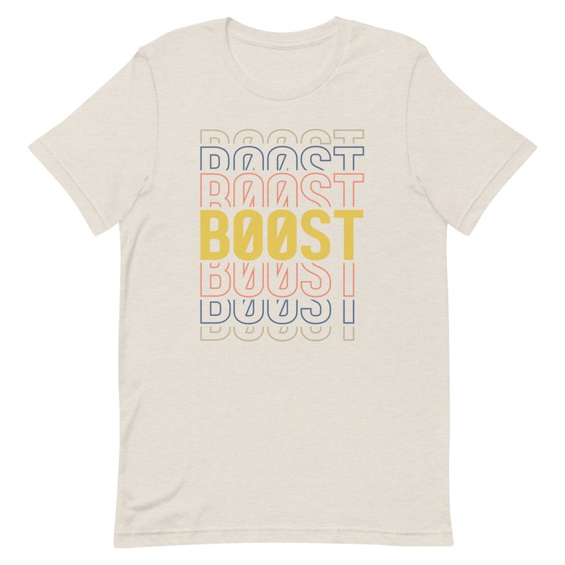 May include: A beige t-shirt with a graphic design of the word "BOOST" in yellow, with the word "BOOST" repeated in different colors and sizes above and below the main word.
