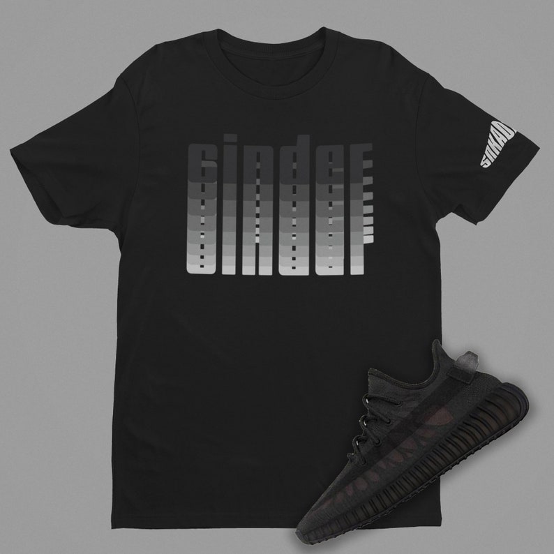 May include: Black t-shirt with a gradient print of the word "Ginder" and a black sneaker with a camouflage pattern.