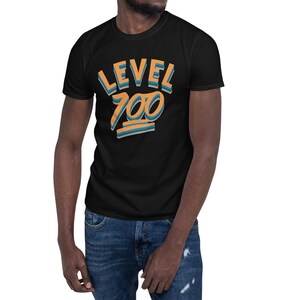 Pode incluir: Camiseta preta com um design gr&aacute;fico que diz "LEVEL 700" em letras laranja e azul.
