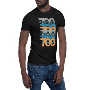 May include: A black t-shirt with a graphic design of the number 700 in a retro style with multiple colors, including orange, blue, and gray.