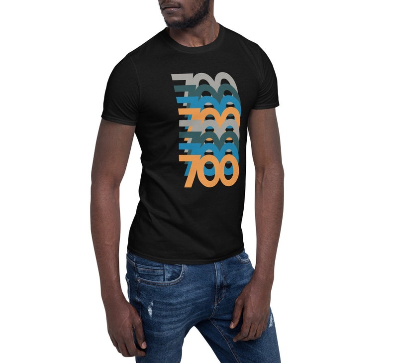 May include: A black t-shirt with a graphic design of the number 700 in a retro style with multiple colors, including orange, blue, and gray.