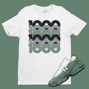 May include: White t-shirt with a graphic of the number 1000 in green, black, and gray circles. Green and white sneakers with a white "N" logo.