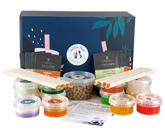 Op de afbeelding: Een blauwe doos met de woorden "Boba Bar" en "bubble tea room" erop. De doos bevat een verscheidenheid aan ingrediënten voor het maken van bubble tea, waaronder theezakjes, boba-parels en rietjes.