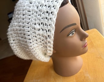 Puede incluir: Un gorro blanco de punto de ganchillo con una trama suelta y abierta. El gorro se muestra en una cabeza de maniquí.