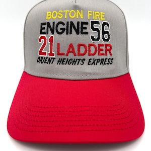 May include: A gray and red baseball cap with embroidered text. The cap features the words "BOSTON FIRE" in yellow, "ENGINE 56" in black, "21 LADDER" in red, and "ORIENT HEIGHTS EXPRESS" in gray.