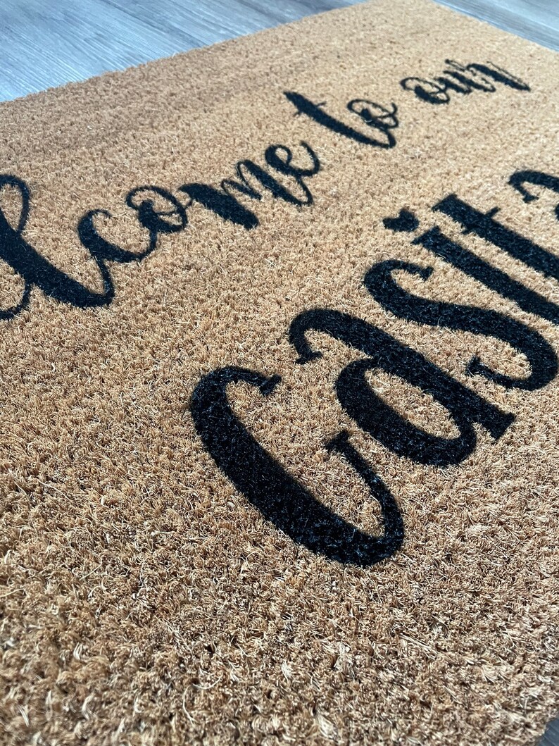 May include: A brown coir doormat with the text "Welcome to our Casita" in black cursive lettering.