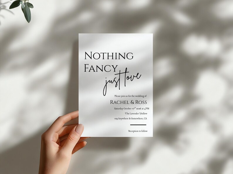 May include: A white wedding invitation with the text "NOTHING FANCY just love" in black script. The invitation includes details for the wedding of Rachel & Ross, including the date, time, and location. The invitation is held by a hand.