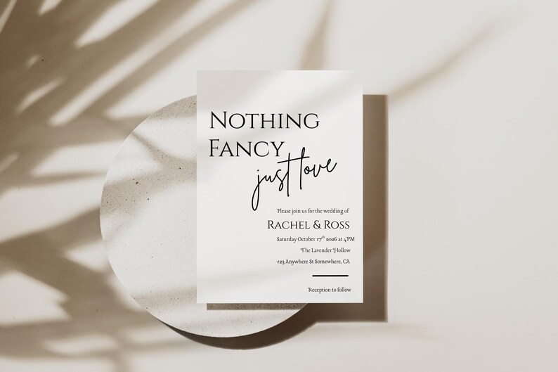 May include: A minimalist wedding invitation with the text "NOTHING FANCY, just love." The invitation includes the names RACHEL & ROSS, the date, time, and location. The invitation is on a white background with a shadow of leaves.
