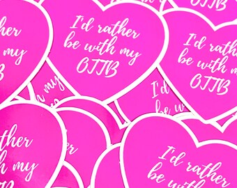 May include: A pile of pink heart-shaped stickers with the text "I'd rather be with my OJTB" printed in white.