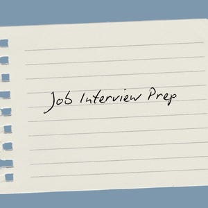 May include: A torn piece of lined paper with the handwritten text "Job Interview Prep" in black ink. The paper is off-white with horizontal lines and a blue background.