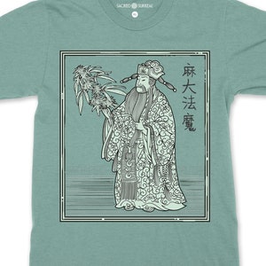 May include: A teal blue t-shirt with a graphic of a man in traditional Chinese clothing holding a cannabis plant. The text "麻大法憲" is printed on the right side of the graphic.