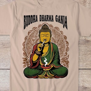 May include: A beige t-shirt featuring a graphic of a meditating Buddha holding a joint. The text "Buddha Dharma Ganja" is printed above the Buddha.