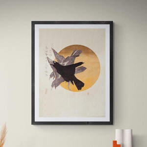Peut inclure: Une estampe en noir et blanc encadrée de trois corbeaux volant devant un soleil jaune. L'estampe est dans un cadre noir et est accrochée à un mur beige clair.