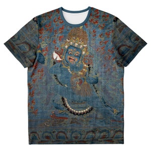 May include: A blue t-shirt featuring a detailed illustration of a deity with a fierce expression. The artwork includes red and gold accents, with a blue background. The design is printed on the entire shirt, including the sleeves.