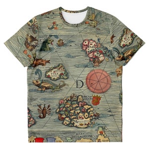 May include: Round-neck t-shirt with a detailed vintage map print. The design includes illustrations of sea creatures, ships, and islands, with Latin text. The colour scheme is muted, featuring blues, greens, and beige tones.