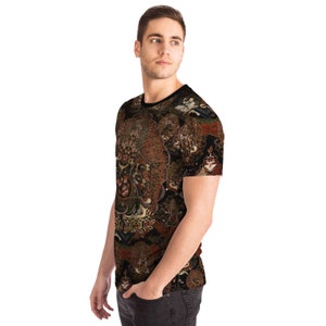 May include: A short-sleeved t-shirt featuring a detailed, ornate pattern in shades of brown, red, and gold against a black backdrop. The design appears to be a complex illustration with figures and symbols. The shirt has a black collar.