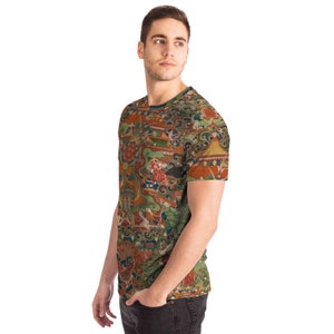 May include: A short-sleeved t-shirt with a colorful, intricate pattern. The design features a mix of orange, green, and blue hues, with detailed illustrations of figures and architectural elements. The shirt has a crew neck and a fitted silhouette.