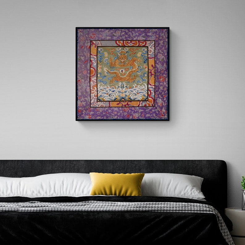 Pode incluir: Uma obra de arte emoldurada apresentando um design bordado colorido de um drag&atilde;o em um mar de ondas. O drag&atilde;o &eacute; dourado e vermelho, e as ondas s&atilde;o azuis e brancas. A moldura &eacute; preta e a obra de arte &eacute; cercada por uma borda roxa com padr&otilde;es florais.