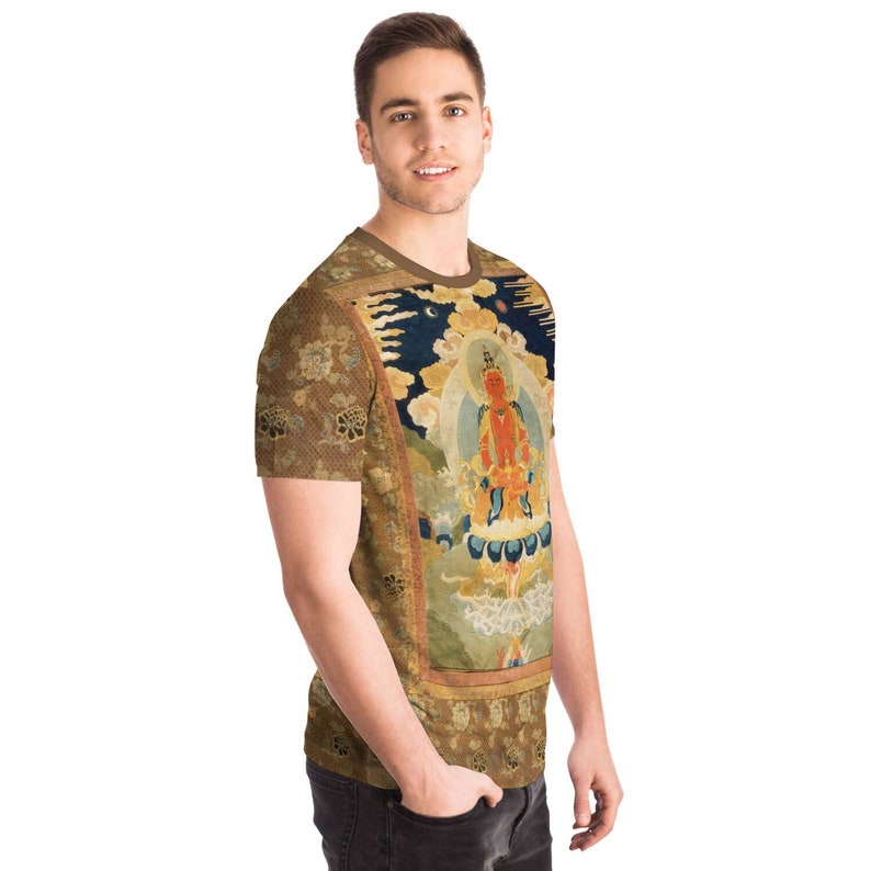 May include: A short-sleeved t-shirt featuring a detailed print of a religious figure. The design includes a central figure in orange and gold, set against a backdrop of blue, gold, and brown tones. The shirt has a brown collar and sleeves with a floral pattern.