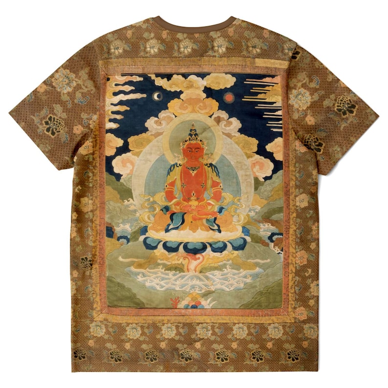 May include: Brown t-shirt featuring a detailed illustration of a seated figure with a halo, set against a backdrop of clouds and a night sky. The shirt has a brown collar and sleeves with a floral pattern.