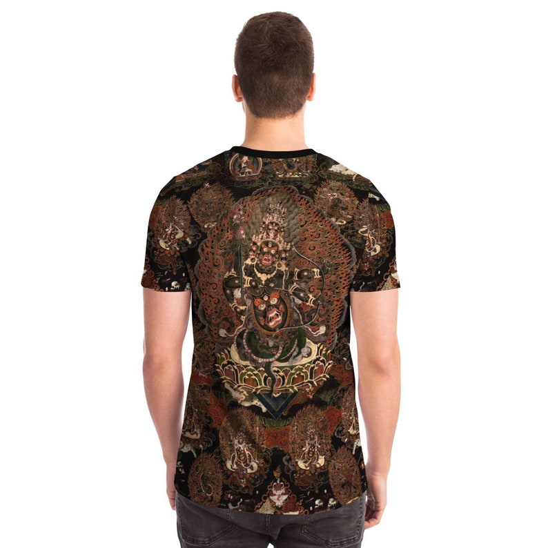 May include: A short-sleeved t-shirt with a detailed, colourful illustration of a deity with multiple arms and a fierce expression. The artwork is set against a dark background with additional figures, creating a complex and ornate design.