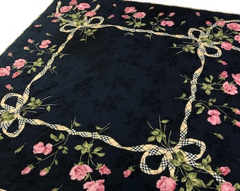 May include: A black silk scarf with a white and yellow plaid ribbon border and pink roses with green leaves. The scarf has a repeating pattern of roses and ribbons.