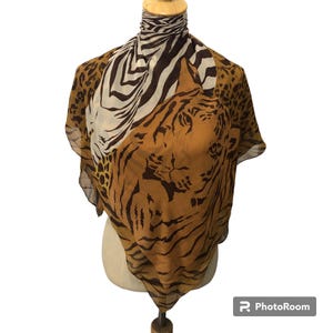 May include: A brown, white, and black silk scarf with a tiger and zebra print.