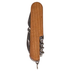 May include: A multi-tool with a wooden handle. The tool includes a knife blade, a corkscrew, and other implements. The handle is a light brown color, and the metal tools are silver. A small metal ring is attached to the end.