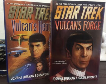 May include: Two paperback books with Star Trek covers. The covers feature a Vulcan character with a pointed ear and a dark blue background. The titles are "Vulcan's Heart" and "Vulcan's Forge".