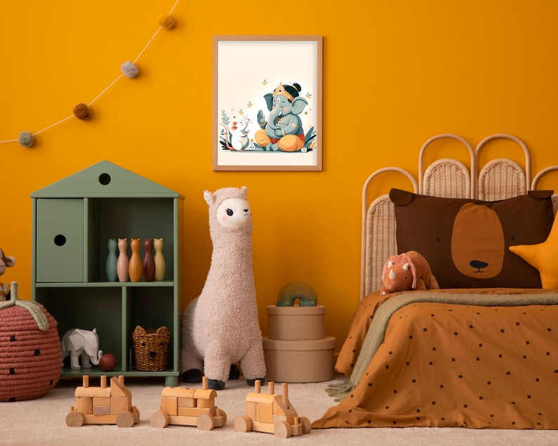 Puede incluir: Una pared amarilla con una ilustraci&oacute;n enmarcada de una deidad elefante azul con una corona y flores. La ilustraci&oacute;n est&aacute; rodeada por un borde blanco y un marco de madera. Un juguete de peluche de llama est&aacute; en primer plano, junto con un estante de madera verde con juguetes y una cama de mimbre marr&oacute;n con un edred&oacute;n estampado en marr&oacute;n y blanco.