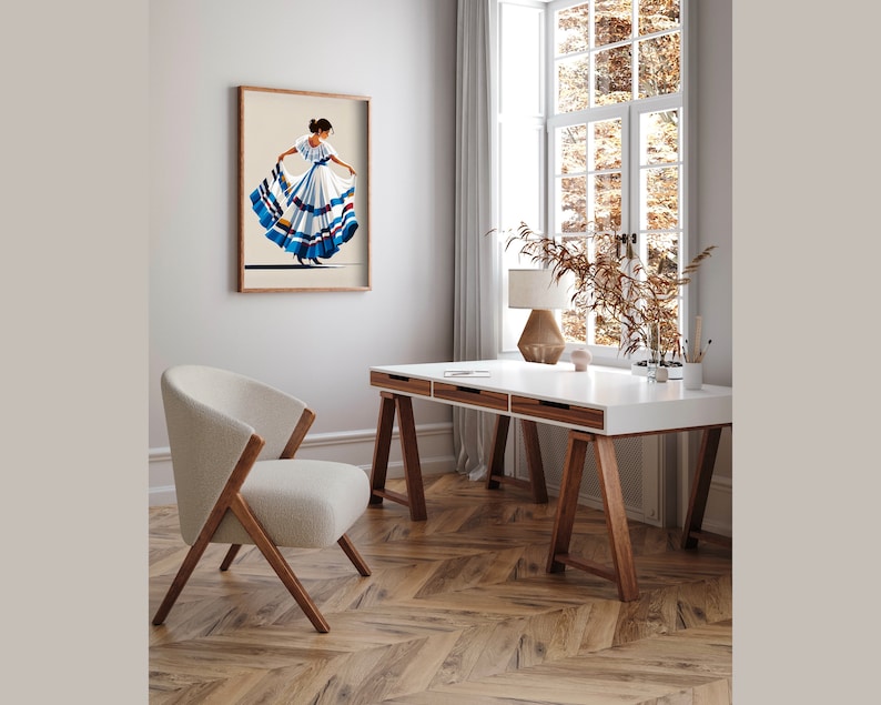 May include: A framed print of a woman in a traditional dress with a full skirt, in shades of white, blue, and brown. The artwork hangs on a neutral-colored wall above a modern desk and chair, creating a stylish interior design.