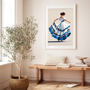 May include: Framed art print featuring a stylized illustration of a woman in a traditional white dress with blue and red accents. The artwork is displayed in a bright, airy room with a wooden bench, a woven basket, and a potted plant.