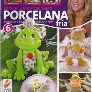 Puede incluir: Una portada de revista con una rana verde que lleva un vestido rosa y blanco, una figurita de ángel blanca y rosa, una figurita de oso marrón y blanco y una mujer con cabello castaño. El título de la revista es "Leticia Suarez del Cerro Porcelana" y el subtítulo es "Modelar y Moldear Porcelana Fria". La portada de la revista también presenta el número "6" en un círculo morado.