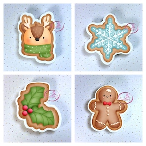 May include: Four Christmas-themed gingerbread cookies: a reindeer with a green scarf, a snowflake, a holly leaf with red berries, and a gingerbread man with a red bow tie.