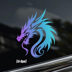 May include: A vinyl decal featuring a stylized dragon head in a gradient of purple and blue. The design displays sharp, flowing lines and a curved neck. Below the dragon, the text "Iri-Opal" is printed in a white, sans-serif font.