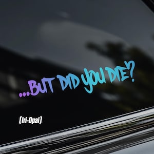 May include: A vinyl decal sticker applied to a dark car window featuring the text ...BUT DID YOU DIE? in a gradient colour scheme transitioning from purple to blue. The text is written in a stylised, bold, sans-serif font with a question mark.