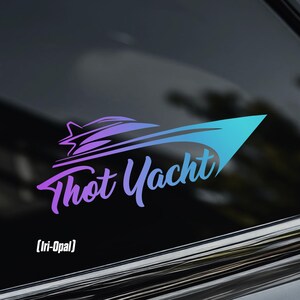 May include: A vinyl decal featuring the words "Thot Yacht" in a stylized, cursive font, with a boat graphic. The design transitions from purple to blue. The text "[Iri-Opal]" is below the main text. The decal is displayed on a car window.