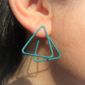 May include: A pair of turquoise triangle shaped earrings. The earrings are made of wire and are double layered.