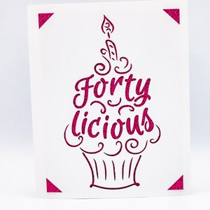 May include: Pink glitter card with a cupcake design and the text "Forty Licious".