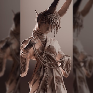 Könnte beinhalten: Detaillierte Skulptur einer Figur mit gehörntem Kopfschmuck und drapierten Kleidungsstücken. Die Figur hält Perlenstränge, und die Skulptur hat ein strukturiertes, monochromes Aussehen.