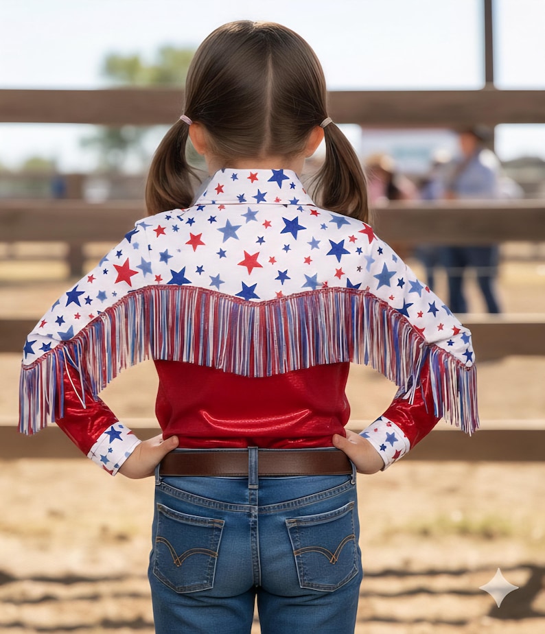 May include: A red, white, and blue star-patterned shirt with fringe. The shirt has a red bodice and long sleeves with star accents. The person is wearing blue jeans and a brown belt. The shirt's design is reminiscent of the American flag.