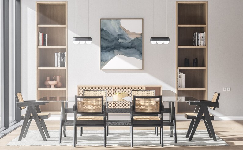 May include: A dining room with a glass table and six black chairs with woven cane seats. The table is set with a bowl of fruit. There are two bookshelves on either side of the table, and a large abstract painting on the wall behind the table.