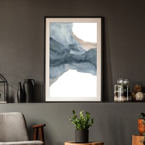 May include: A framed abstract watercolour painting with shades of blue and brown. The painting is on a white background and is framed in a black frame.