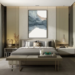 May include: A modern bedroom with a large bed, a grey upholstered headboard, and a grey and white patterned throw pillow. The bed is dressed in grey linens and has a grey bench at the foot of the bed. There is a large abstract painting on the wall behind the bed.