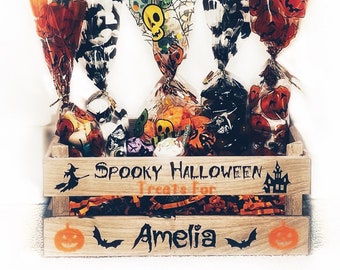 May include: A wooden crate filled with Halloween treats. The crate is decorated with the words "Spooky Halloween Treats for Amelia" and a pumpkin, bat, and haunted house design.