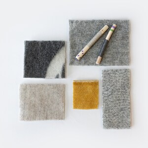 May include: Five fabric swatches in different colors and textures. The swatches are arranged in a grid pattern. The swatches are gray, beige, yellow, and two shades of gray.