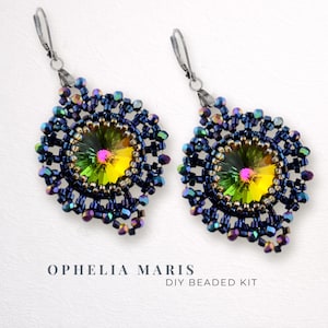 Puede incluir: Un par de pendientes de cuentas hechos a mano con un cristal iridiscente central. Los pendientes presentan un diseño de cuentas azul oscuro alrededor del cristal, con un gancho plateado. El texto "Ophelia Maris DIY Beaded Kit" es visible.