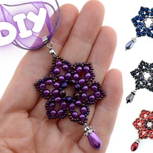 Könnte beinhalten: Eine handgefertigte lila Perlen-Stern-Anhänger-Halskette mit einem Tropfen-Charm. Die Halskette wird auf einer Hand präsentiert, mit drei weiteren Stern-Anhängern in Blau, Schwarz und Rot. Das Wort "DIY" ist sichtbar.